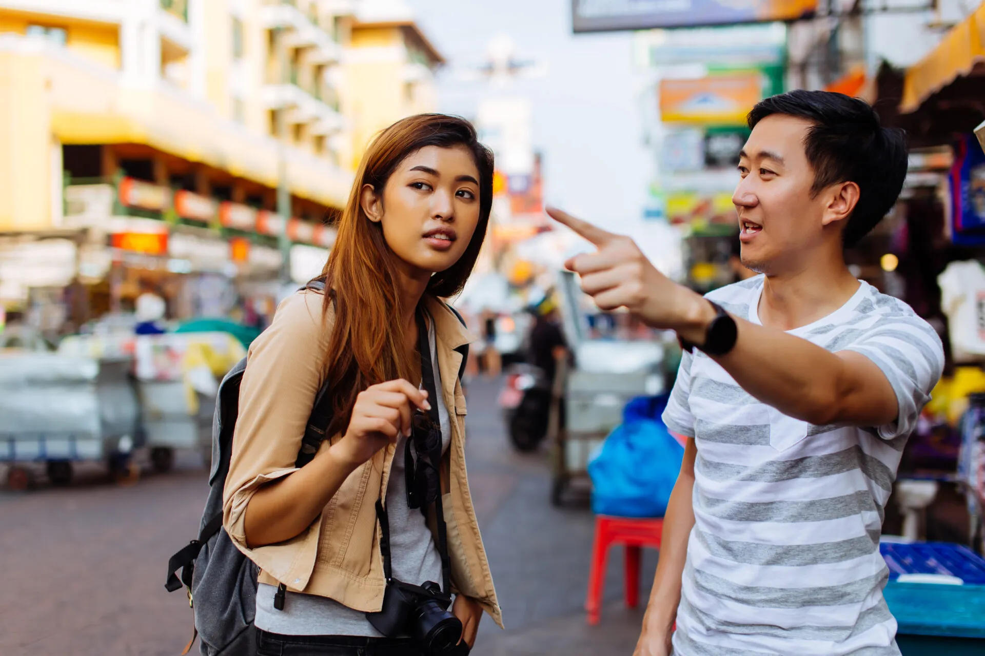 Young female tourist asking for directions and help from local people in Bangkok, Thailand